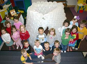 HOMEMADE IGLOO -- After their students brought in 213 milk jugs, teachers at the Stewartville Child Care Center used hot glue to make a unique igloo. Here, Child Care Center students gather around the igloo, in front, from left, Andy Teal, Owen Rommel, Trenton Erickson, Ava Krueger, Ian Hoot and Zeke Zodrow. In back, from far left, Kahleigh Dawson, Madelynn Kropp, Zoey Zodrow, Summer Barber, Amelia Mascotti, Anna Haug, Tyrone Erickson, Kendyl Dawson, Brooke Bartsch, Ava Higgins, Mateo Anderson, and in back, Abby Teal and Makayla Kennedy. 
