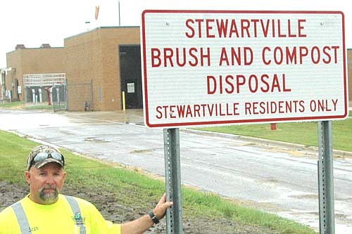 Sean Hale, public works director for the city of Stewartville, displays the new sign at the entrance to the city's brush dump. Hale emphasized that the dump accepts brush, branches and compost from Stewartville residents only. The city is still having problems with people leaving garbage and debris at the dump, he said.