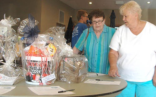 Joyce Erickson of Rochester, left, and Carol Higgins of Oronoco browse among the silent auction items at the benefit for Les Severson at the Stewartville American Legion Post 164 on Saturday, July 21.Guests bid on scores of items for the silent auction, including a collection of salad dressings from Jimmy's Salad Dressings & Dips, a Cowboy Jack's basket, a wine and spaghetti basket from Anita Wendt, and many more.