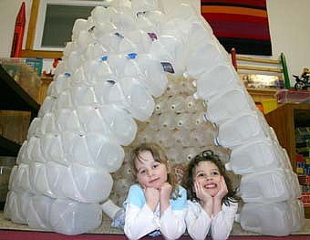 HOMEMADE IGLOO -- After their students brought in 213 milk jugs, teachers at the Stewartville Child Care Center used hot glue to make a unique igloo. Above, from left, Makayla Kennedy and Abby Teal enjoy the view from the igloo's entrance. 