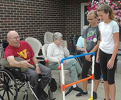 David Wendt, a resident of the Stewartville Care Center, left, makes a toss during the ladder game. YES group students, at right, from left, include Ella Bly and Addison Eide. Hazle Robinson, center, is another Care Center resident. 