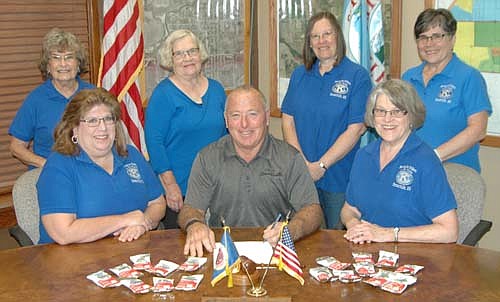 Mayor Jimmie-John King, seated in center, signed a proclamation last week declaring Friday, Sept. 7 and Saturday, Sept. 8 Peanut Days in Stewartville. Members of the Stewartville Kiwanis Club who will be at Fareway and Casey's south to accept donations to fight deadly yet preventable maternal and neonatal tetanus on those two days include, front row with Mayor King, from left, Lori Torgerson and Mary Brouillard, and back row, from left, Margaret Clark, Janice Hagen, Barb Howes and Glynis Sturm. Local and area residents who donate will be offered a bag of peanuts. Maternal and neonatal tetanus (MNT)&#8200;is still killing mothers and their newborn babies in Africa, the Middle East and the Asian Pacific.