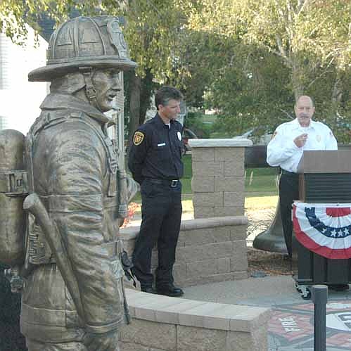 Steve Wolf, assistant fire chief, standing at the podium, was the opening speaker as the Stewartville Fire Department dedicated its new memorial near the Stewartville Fire Hall on a sunny and mild Patriot Day, Tuesday evening, Sept. 11. Wolf, one of four committee members who planned the memorial.