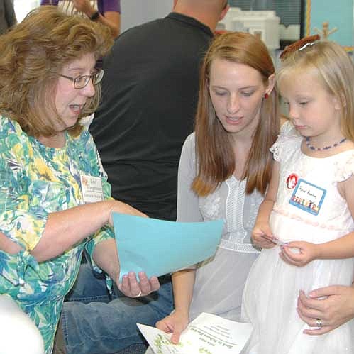 Christina Boone of Racine, center, brought her daughter Rose, 3 1/2, to the annual Wee Care open house on Sunday afternoon, Sept. 9. The Boones listen as Lori Torgerson, Wee Care caterpillar teacher, left, welcomes them to the learning center.