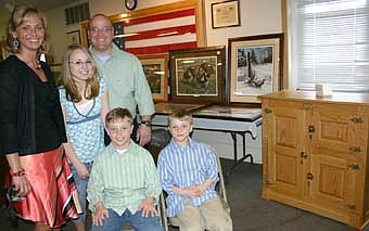 The Miller family poses near a cabinet and artwork that were auctioned off to help the family raise money to pay the medical bills that have mounted since Kory Miller donated a kidney to his 10-year-old son Caleb last September.  Almost 1,000 people attended a fund-raising event at the Stewartville Sportsman's Club on Saturday, April 19, raising more than $50,000.  Family members include, front row, from left, Colton and Caleb. Standing, from left, Christy, Madelyn and Kory. 