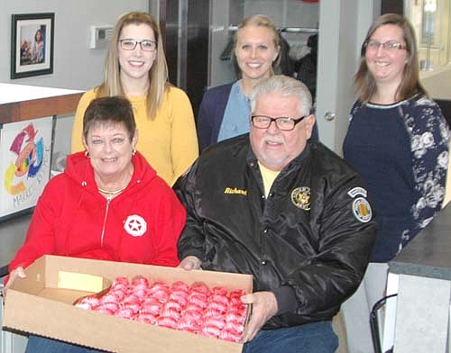 Members of the Stewartville American Legion Post 164 and Auxiliary Unit 164 celebrated American Education Week by delivering cupcakes to the staffs at all local schools last week, including the teachers and staff members at Bear Cave Intermediate School. Seated from left, Peggy and Richard Paulson, representing the Legion Auxiliary and the Legion, respectively, deliver cupcakes to Bear Cave fourth-grade teachers, standing from left, Regan Lonien, Leah Campbell and Mary Shafer.