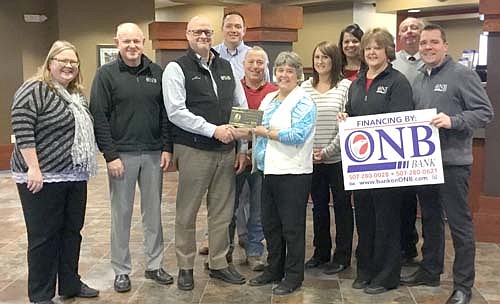 Brad Becker, president of ONB Bank, third from left, accepts a "Welcome to the Chamber" plaque from Myrna Welter, Chamber membership coordinator, as the Stewartville Area Chamber of Commerce makes an ambassador visit to the new bank on Tuesday, Dec. 4. Other Chamber members and officials, along with ONB employees, include from left, Gwen Ravenhorst, Chamber administrator; Pete Erickson of ONB Bank; Nick Johnson of Thrivent Financial; Mayor Jimmie-John King; Alisha Nelson, First American Insurance; Andrea Eickhoff, ONB Bank; Ann Lutteke, ONB Bank; Bill Schimmel Jr., city administrator; and Josh Buckmeier, ONB Bank.