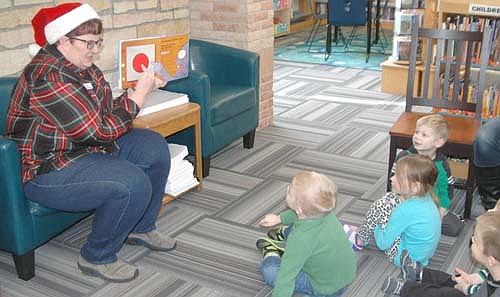 Sue Edge, librarian at the Stewartville Public Library, left, read Christmas stories to a group of children and their mothers during story time at the Stewartville Public Library on Tuesday morning, Dec. 11. Debbie Lofgren, another librarian, joined the fun by distributing strings of bells to the children, who rang the bells as the group danced and sang Jingle Bells