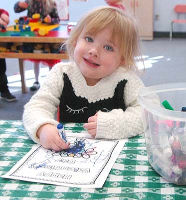 Izabelle Slovinski, 4, looks up from her Valentine's Day coloring project at St. John's Wee Care on Feb. 14.