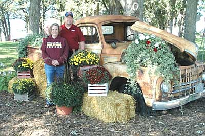 Joe and Jill Haggerty, who live along Hwy. 30 near Stewartville, pose near their 1950 International pickup truck, decorated with mums, ivy and more, in September.
