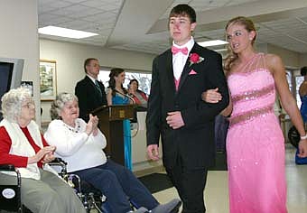 PROMENADE -- Jake Flynn and Kelly Norman joined a number of other couples who visited the Stewartville Care Center before boarding a bus bound for Stewartville High School prom festivities in Mankato on Saturday, April 19.  Care Center residents enjoyed seeing the couples in their prom finery. 