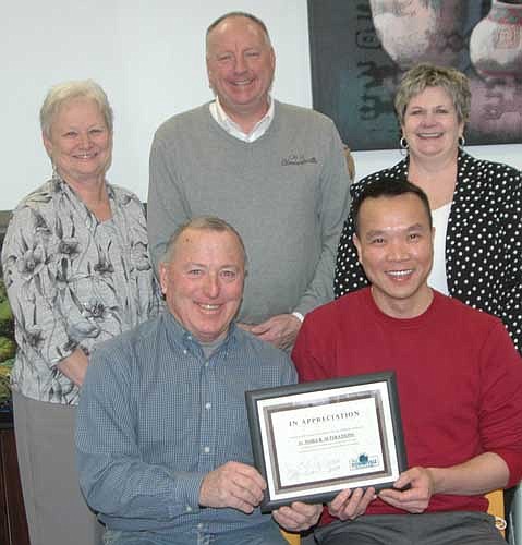 Mayor Jimmie-John King, representing the city of Stewartville's Economic Development Authority, seated at left, presents the EDA's Business Appreciation Award to Tri Nguyen, owner of A+ Nails of Stewartville. In back, from left, are Barb Neubauer, city finance director; Bill Schimmel Jr., city administrator; and Cheryl Roeder, city clerk.