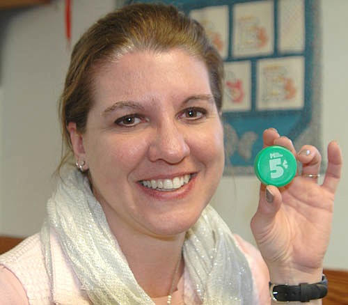 Dee Radtke, director of the Wee Care Learning Center at St. John's Lutheran Church, displays a Kwik Trip Milk Moola bottle cap. Radtke heard last week that Kwik Trip is ending its Milk Moola fundraising program and wanted to share the news with the community.